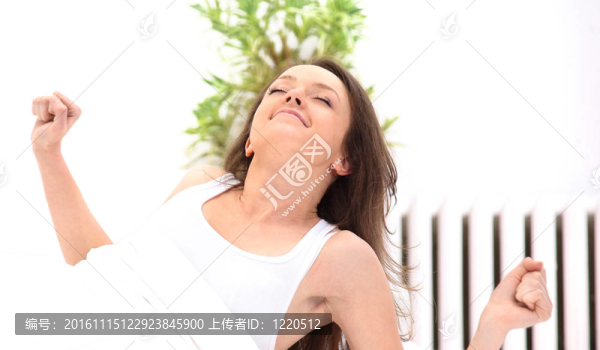 美麗的年輕女子躺在床上醒來