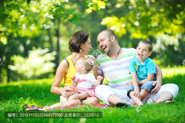 快樂的年輕夫婦和他們的孩子在公園玩得開心