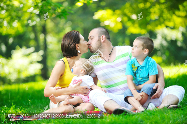 快樂的年輕夫婦和他們的孩子在公園玩得開心