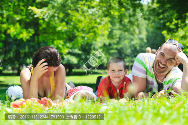 快樂的年輕夫婦和他們的孩子在公園玩得開心