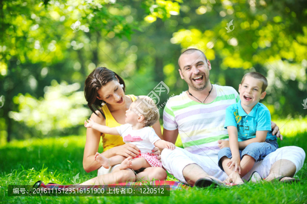 快樂的年輕夫婦和他們的孩子在公園玩得開心
