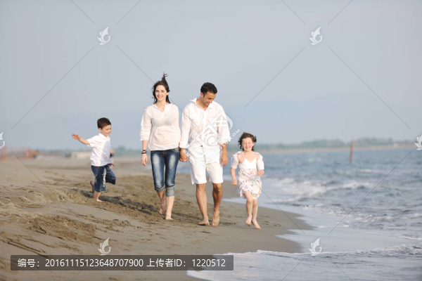 快樂的年輕家庭在海灘上玩得很開心