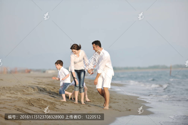 快樂的年輕家庭在海灘上玩得很開心