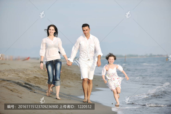 快樂的年輕家庭在海灘上玩得很開心