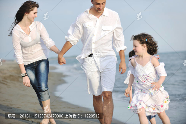 快樂的年輕家庭在海灘上玩得很開心