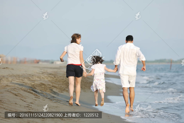快樂的年輕家庭在海灘上玩得很開心