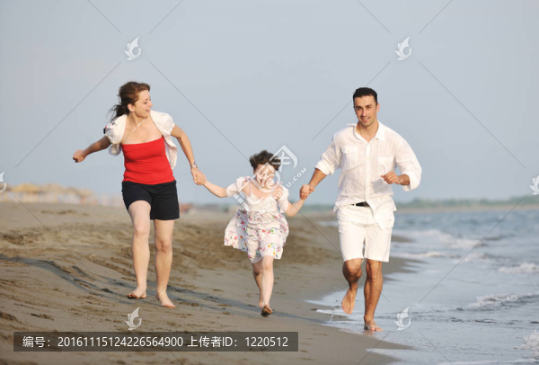 快樂的年輕家庭在海灘上玩得很開心