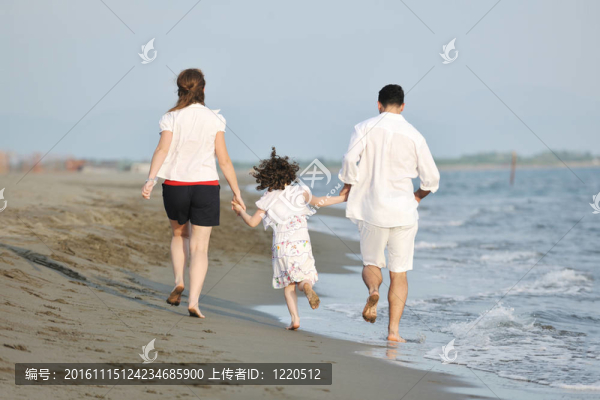 快樂的年輕家庭在海灘上玩得很開心