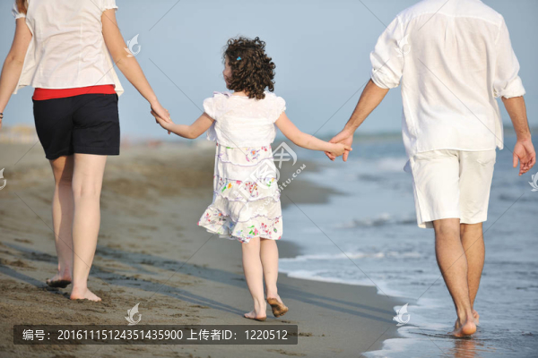 快樂的年輕家庭在海灘上玩得很開心