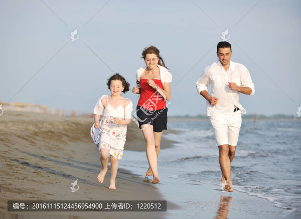 快樂的年輕家庭在海灘上玩得很開心