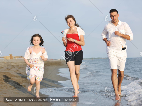 快樂的年輕家庭在海灘上玩得很開心