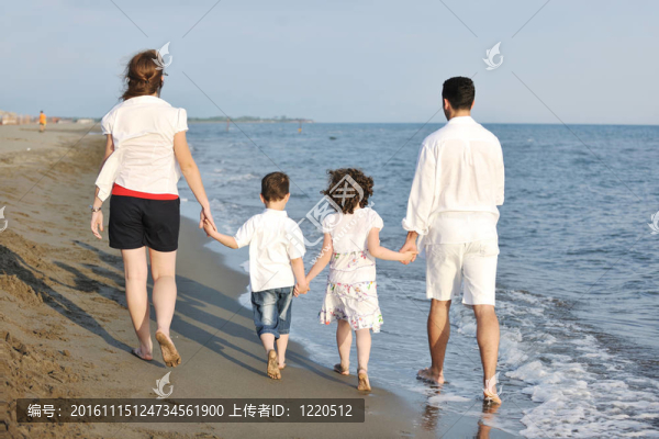 快樂的年輕家庭在海灘上玩得很開心