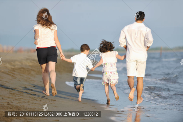 快樂的年輕家庭在海灘上玩得很開心