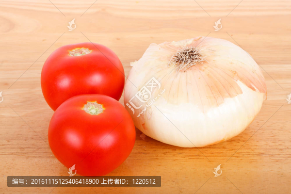木板上有兩個西紅柿和一個洋蔥