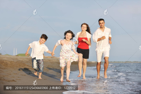 快樂的年輕家庭在海灘上玩得很開心