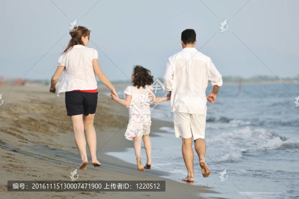 快樂的年輕家庭在海灘上玩得很開心