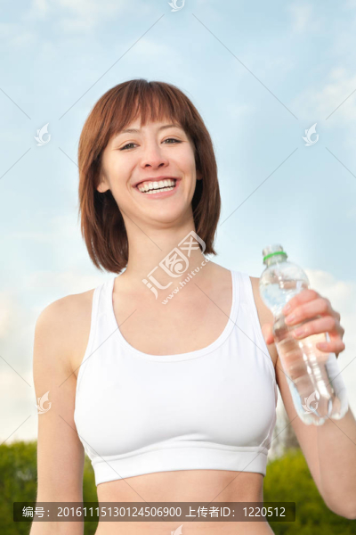 年輕的運動婦女與礦泉水瓶