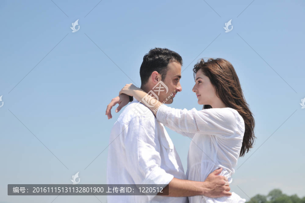 快樂的年輕夫婦在海灘上玩得很開心