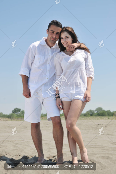 快樂的年輕夫婦在海灘上玩得很開心