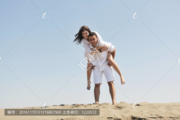 快樂的年輕夫婦在海灘上玩得很開心