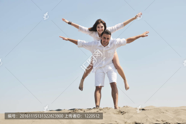 快樂的年輕夫婦在海灘上玩得很開心