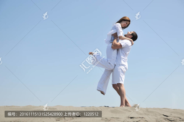 快樂的年輕夫婦在海灘上玩得很開心
