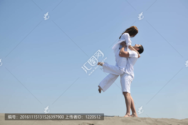 快樂的年輕夫婦在海灘上玩得很開心