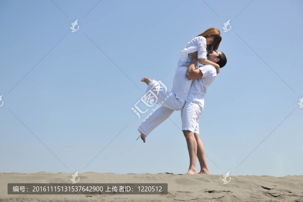 快樂的年輕夫婦在海灘上玩得很開心