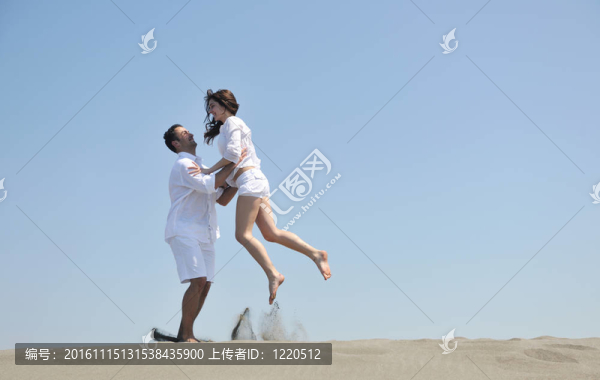 快樂的年輕夫婦在海灘上玩得很開心