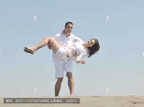 快樂的年輕夫婦在海灘上玩得很開心