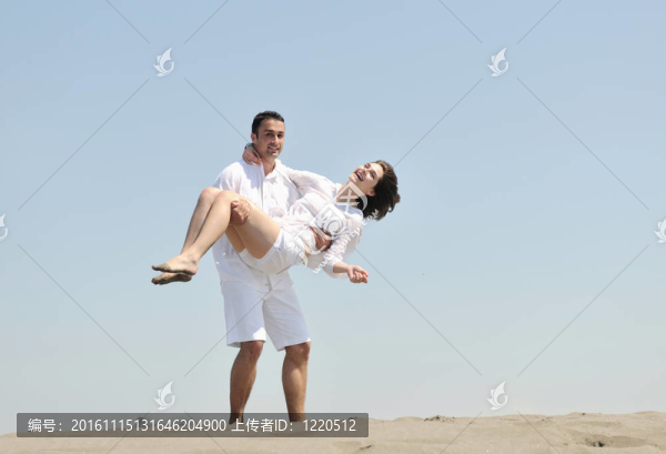 快樂的年輕夫婦在海灘上玩得很開心