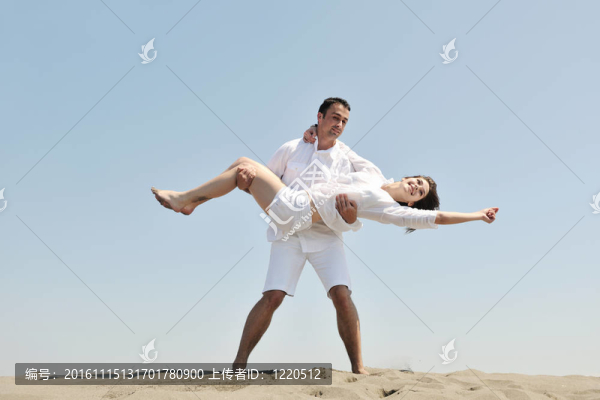 快樂的年輕夫婦在海灘上玩得很開心