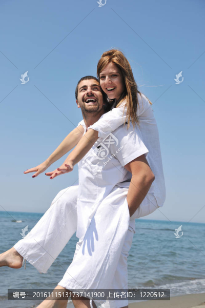 快樂的年輕夫婦在海灘上玩得很開心