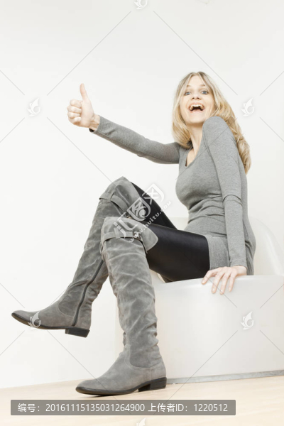 坐著的女人穿著時髦的灰色靴子