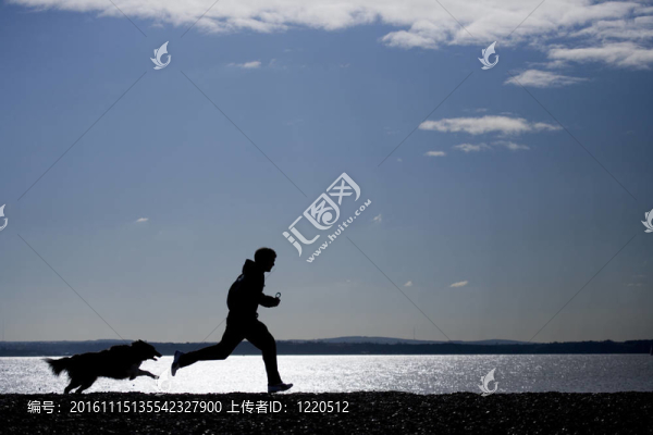 男子與狗在海灘上跑步