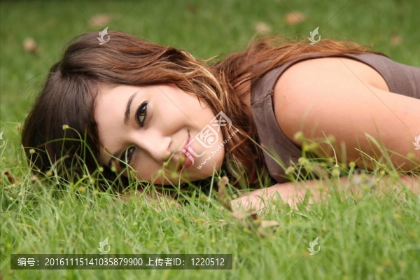 美麗的女人在草地上放松