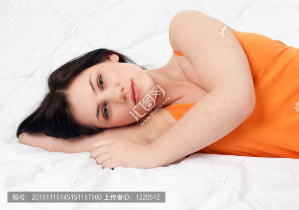 美麗的年輕女子躺在白色的床上