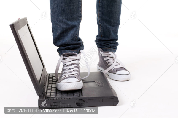 在運(yùn)動鞋上的人站在筆記本電腦上