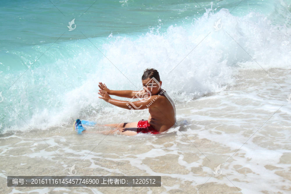 小男孩坐在海上停浪