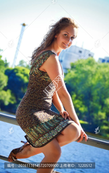 美麗的女人坐在欄桿上