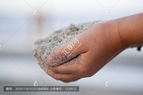 孩子握著手中的沙子