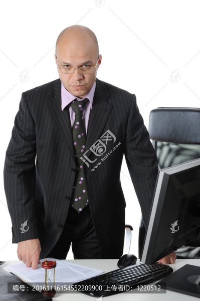 商人站在他辦公室的桌子旁。