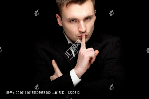 穿著黑色西裝的嚴肅商人；雙手交叉；保持沉默；黑色背景