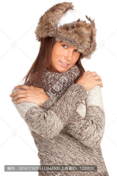 白色的冬天帽子和灰色溫暖的毛衣的年輕女人