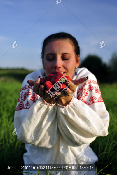 俄羅斯女孩在傳統(tǒng)的服裝舉行草莓在手
