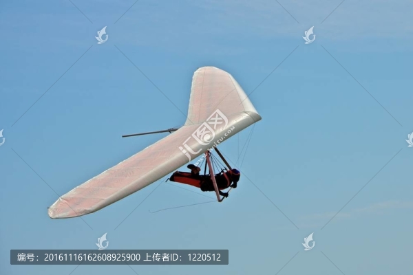 懸掛滑翔男子在白色的翅膀與天空的背景