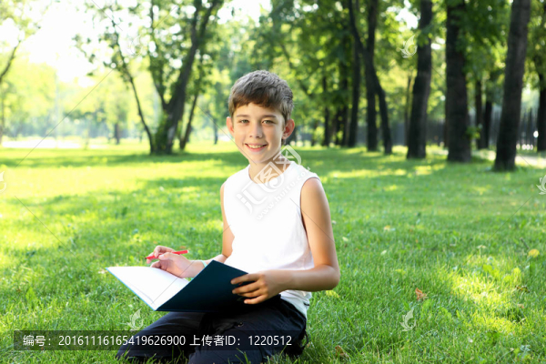 一個男孩在公園里拿著一本書的肖像