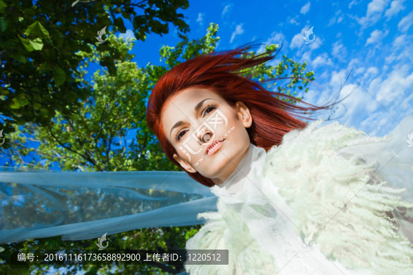 美麗的女人在白色的藍(lán)天和綠樹