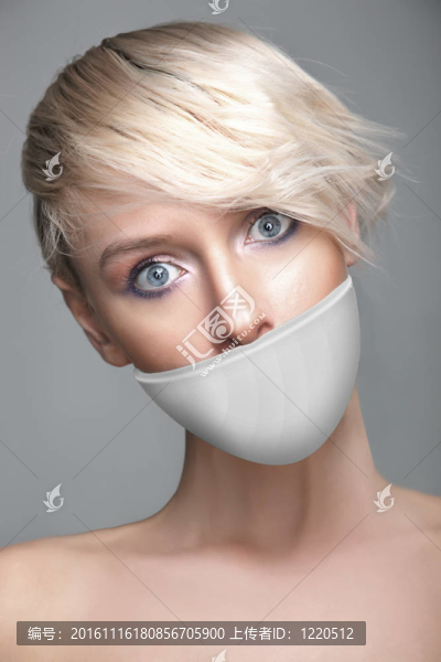 可愛的年輕女人嘴上帶著白色的帶子