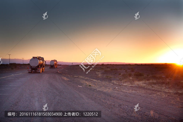 兩輛卡車在日出時的道路上